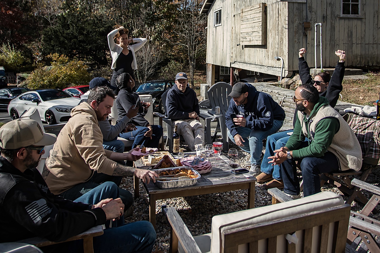 Group around a table with food and wine after the drive, barn behind